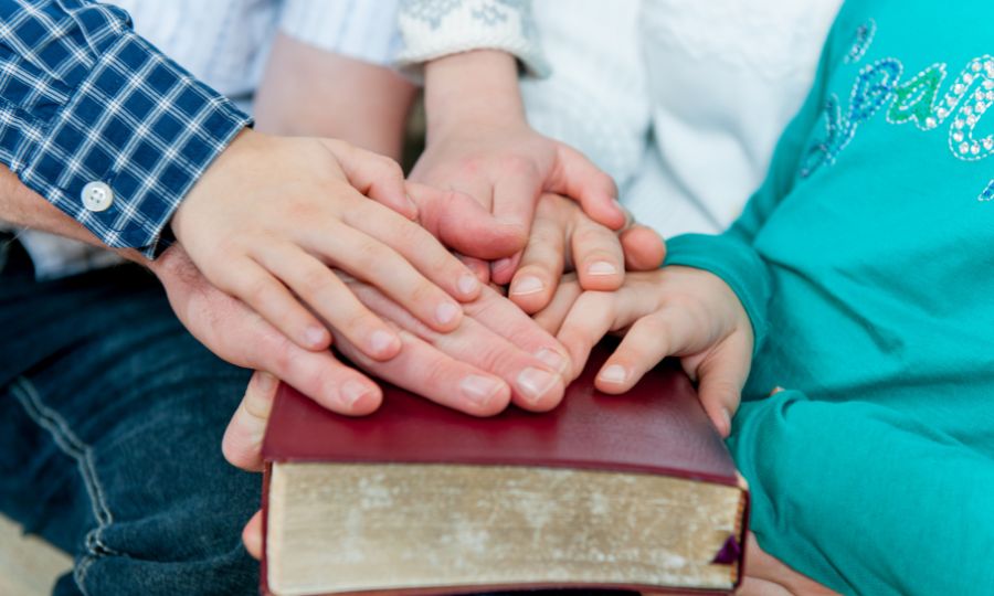 mãos-de-pais-e-crianças-sobre-a-bíblia