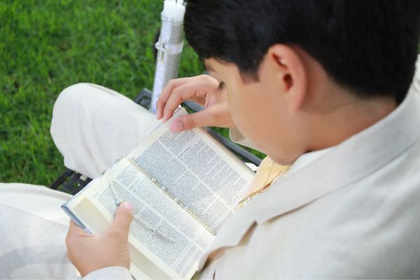 criança lendo a biblia aberta
